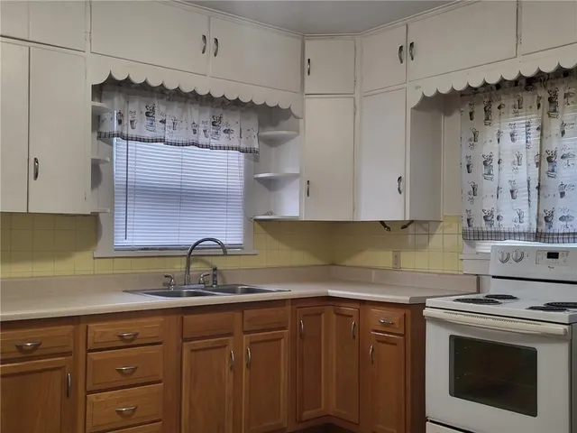 a kitchen with granite countertop a sink stove and cabinets