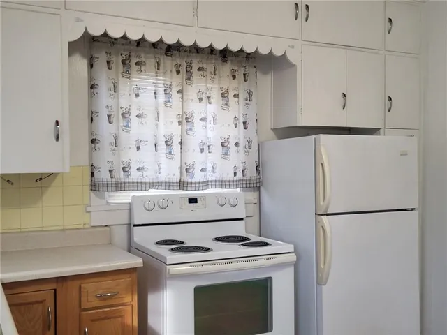 a kitchen with granite countertop cabinets stainless steel appliances and wooden floor