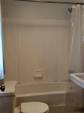 a bathroom with a toilet and a shower