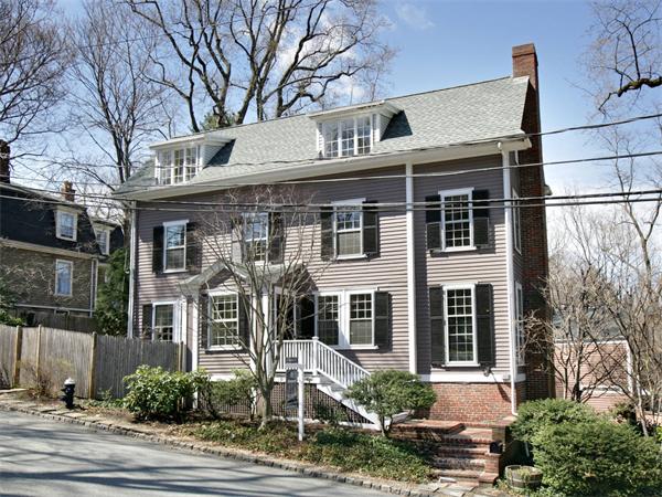 a front view of a house with yard and parking
