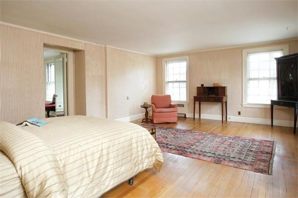 21 Fairmount Street Brookline, MA 02445 - Photo 6 of 10 a spacious bedroom with a bed a table and large mirror with wooden floor
