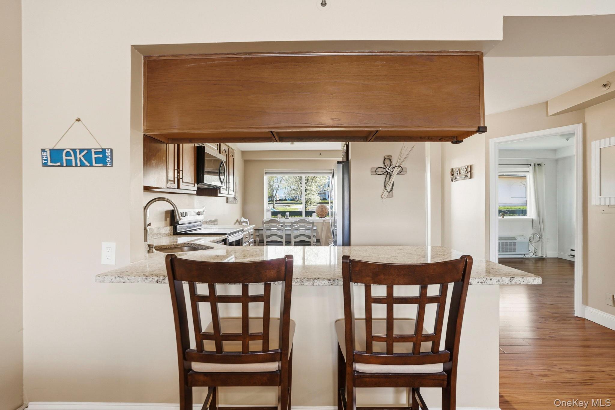 4 Marina Drive, Unit D2 Mahopac, NY 10541 - Photo 14 of 39 The kitchen features a breakfast bar with a granite-style countertop, stainless steel appliances, and wood cabinetry