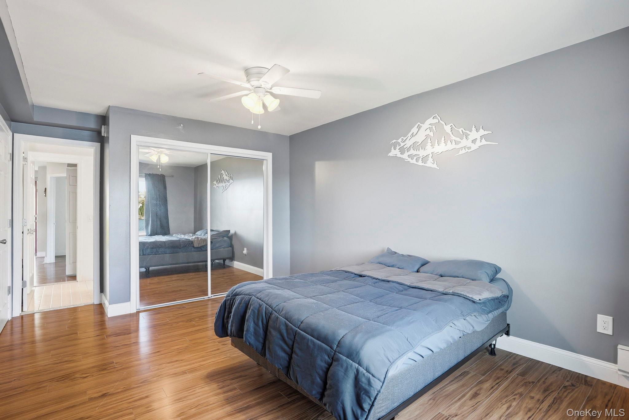 4 Marina Drive, Unit D2 Mahopac, NY 10541 - Photo 16 of 39 Bedroom featuring hardwood style flooring, a ceiling fan, and mirrored closet doors