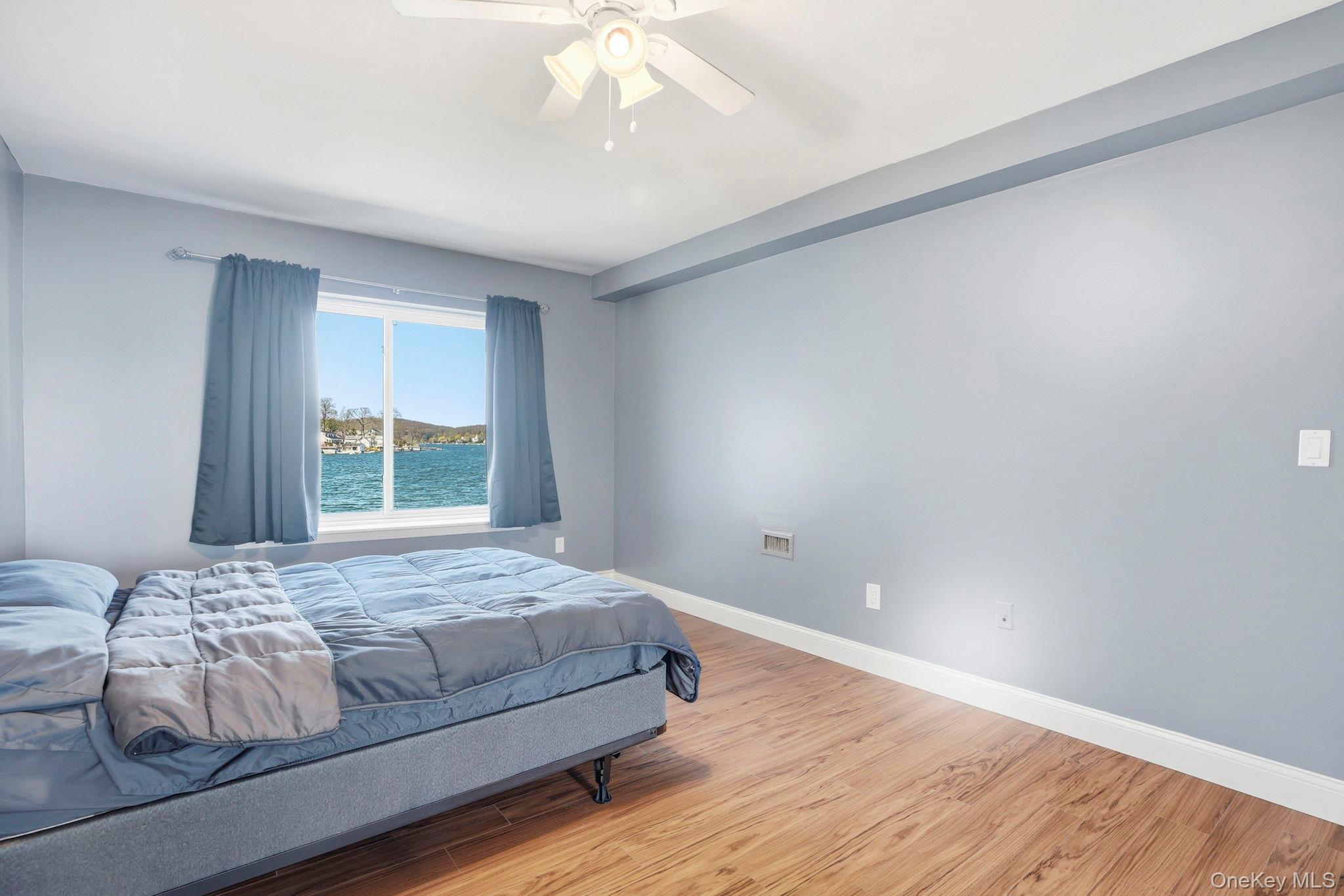 4 Marina Drive, Unit D2 Mahopac, NY 10541 - Photo 18 of 39 This room features light blue walls, hardwood flooring, and a window offering a water view