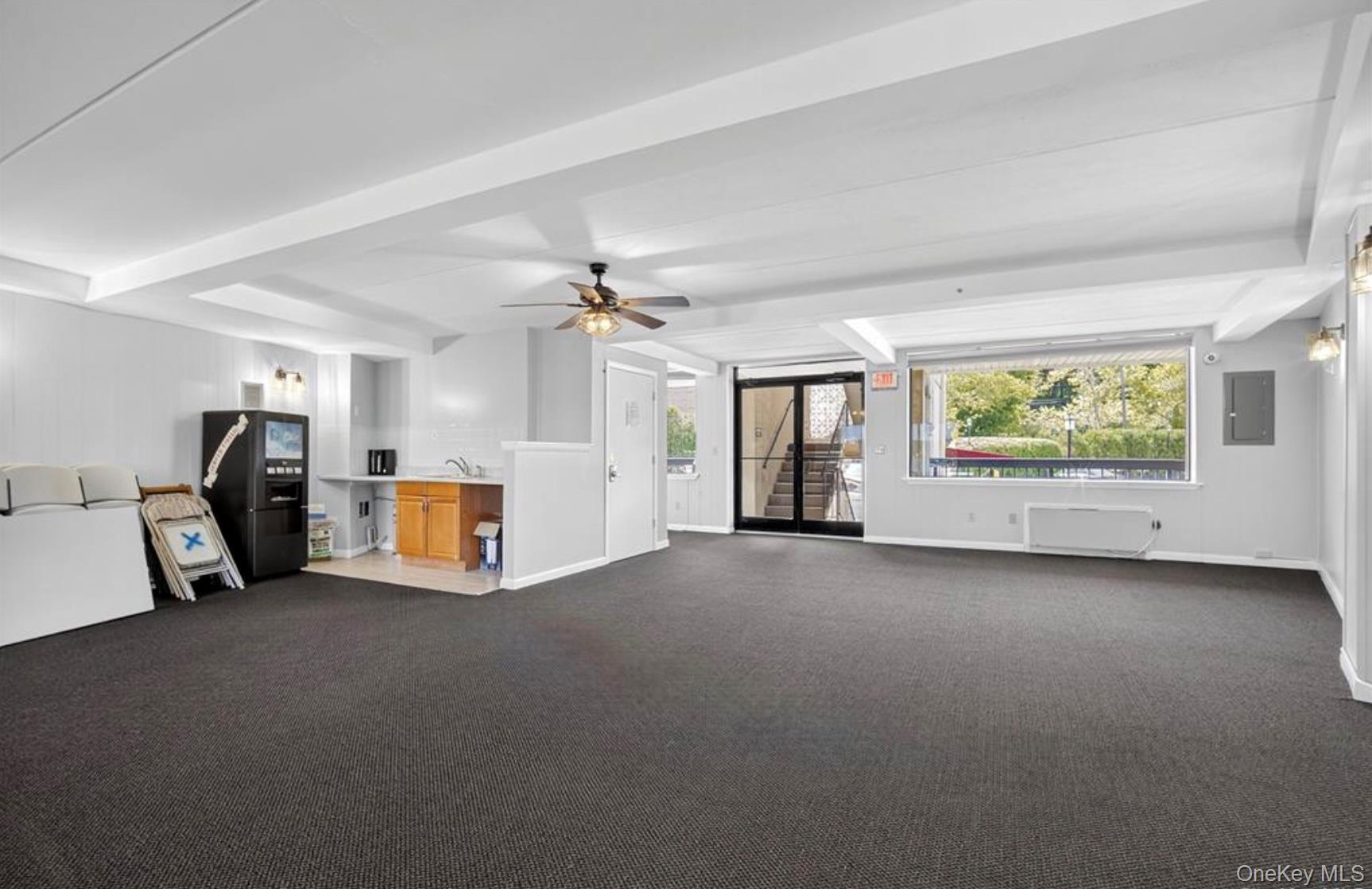 4 Marina Drive, Unit D2 Mahopac, NY 10541 - Photo 35 of 39 Spacious room featuring dark carpet flooring, a ceiling fan, and large windows that provide a view of the outdoors