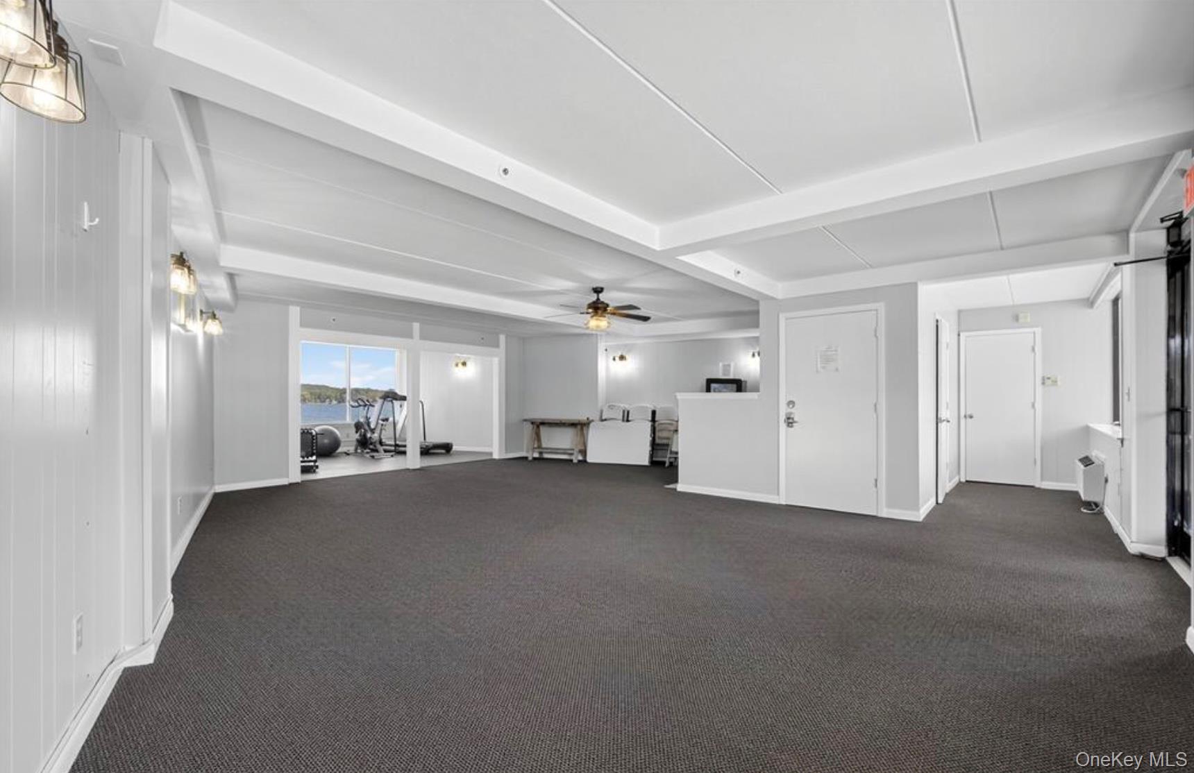 4 Marina Drive, Unit D2 Mahopac, NY 10541 - Photo 36 of 39 Spacious room with dark carpeting, white walls, and exposed ceiling beams