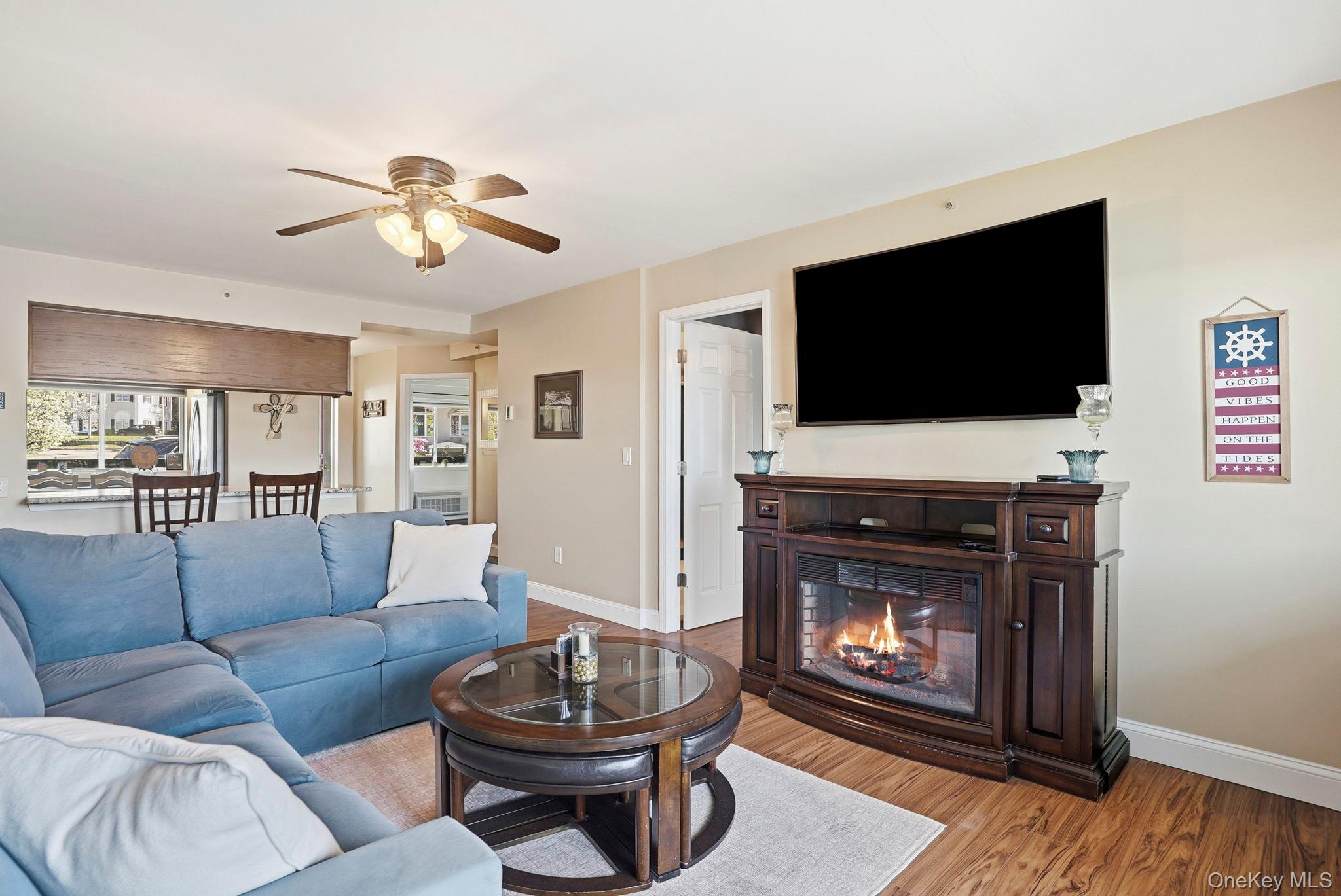 4 Marina Drive, Unit D2 Mahopac, NY 10541 - Photo 5 of 39 Living area featuring wood flooring, a ceiling fan, and a fireplace with a mantel