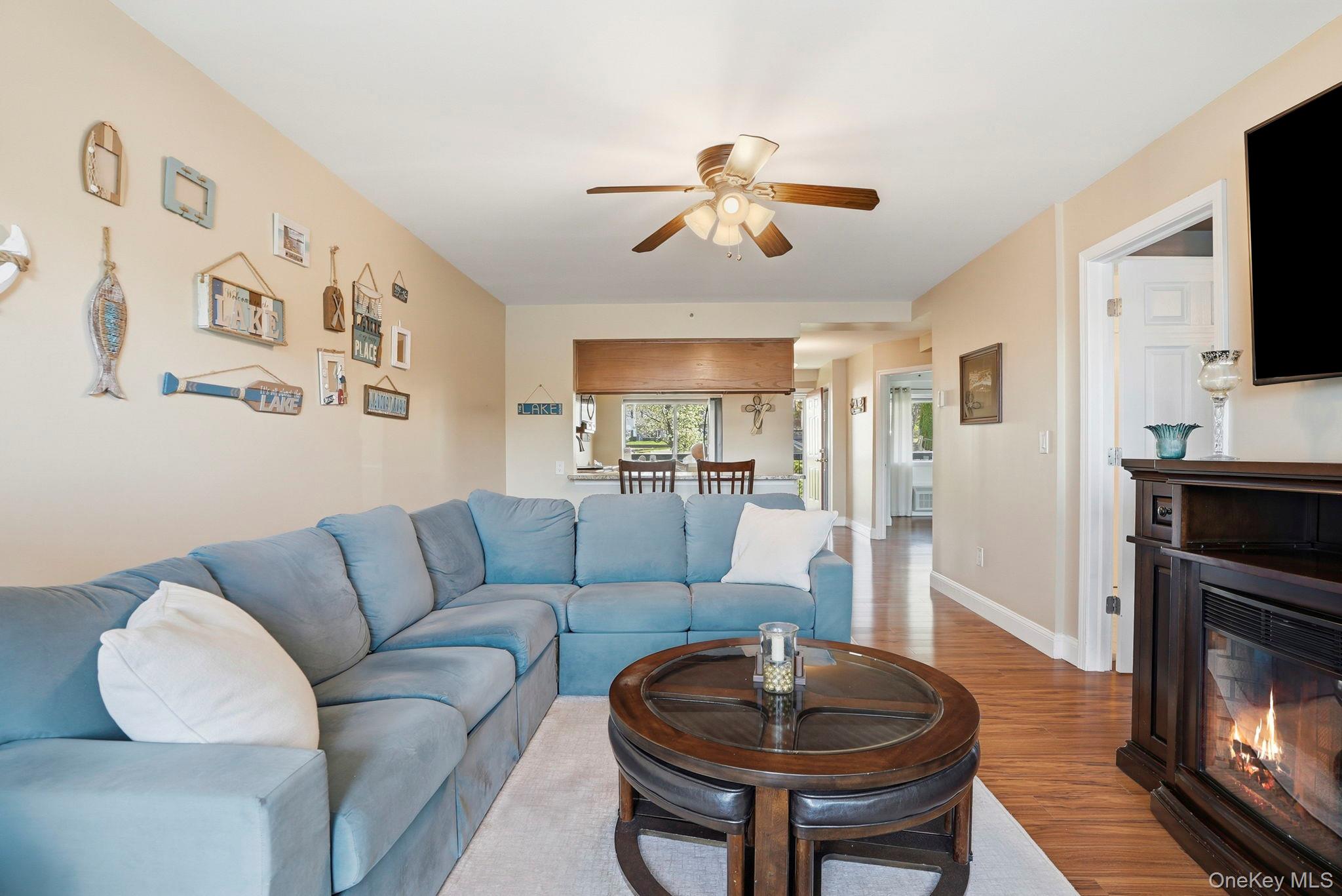 4 Marina Drive, Unit D2 Mahopac, NY 10541 - Photo 6 of 39 The living area features hardwood flooring, a ceiling fan, and a fireplace