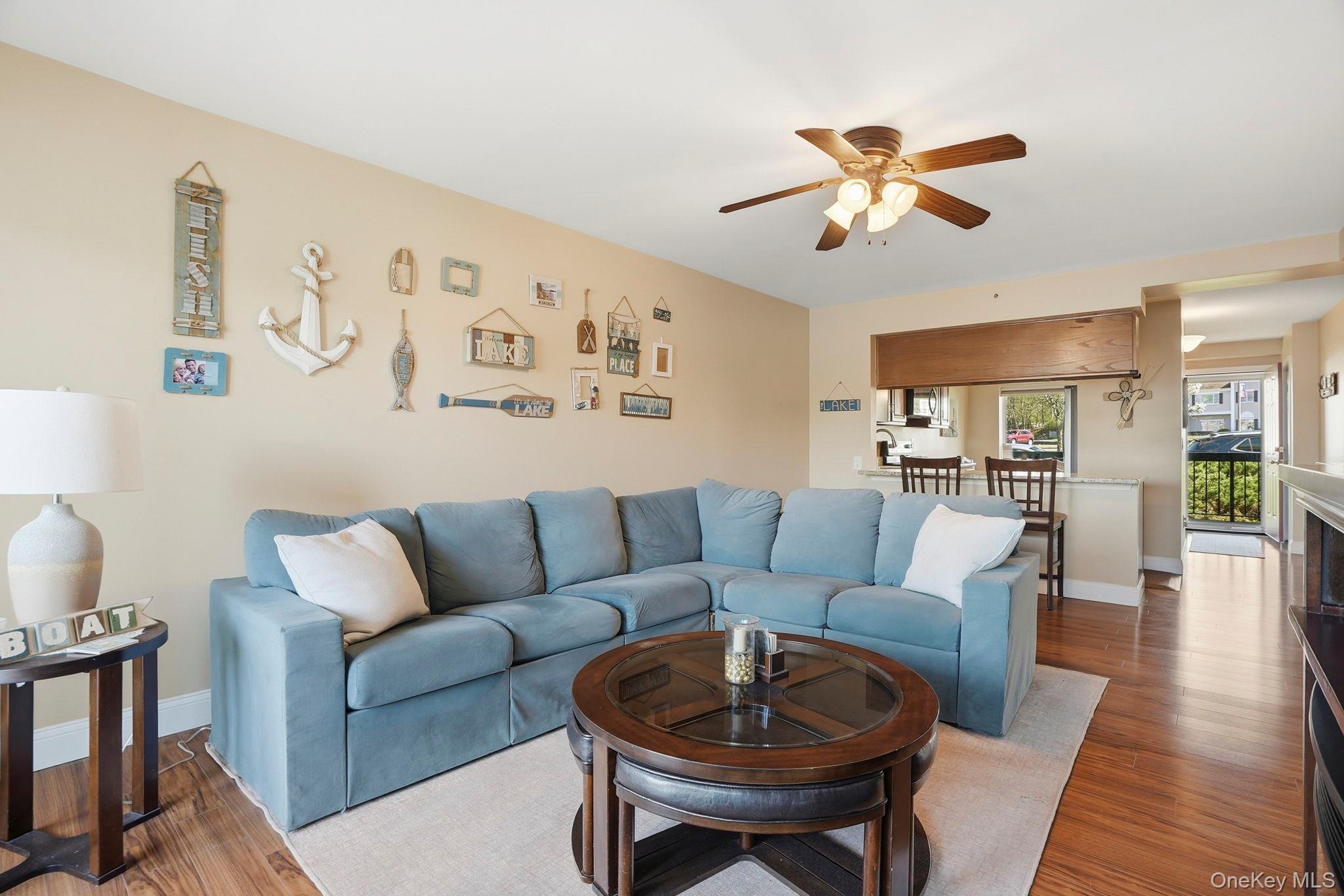 4 Marina Drive, Unit D2 Mahopac, NY 10541 - Photo 7 of 39 The living area features hardwood flooring, a ceiling fan, and a light-colored area rug