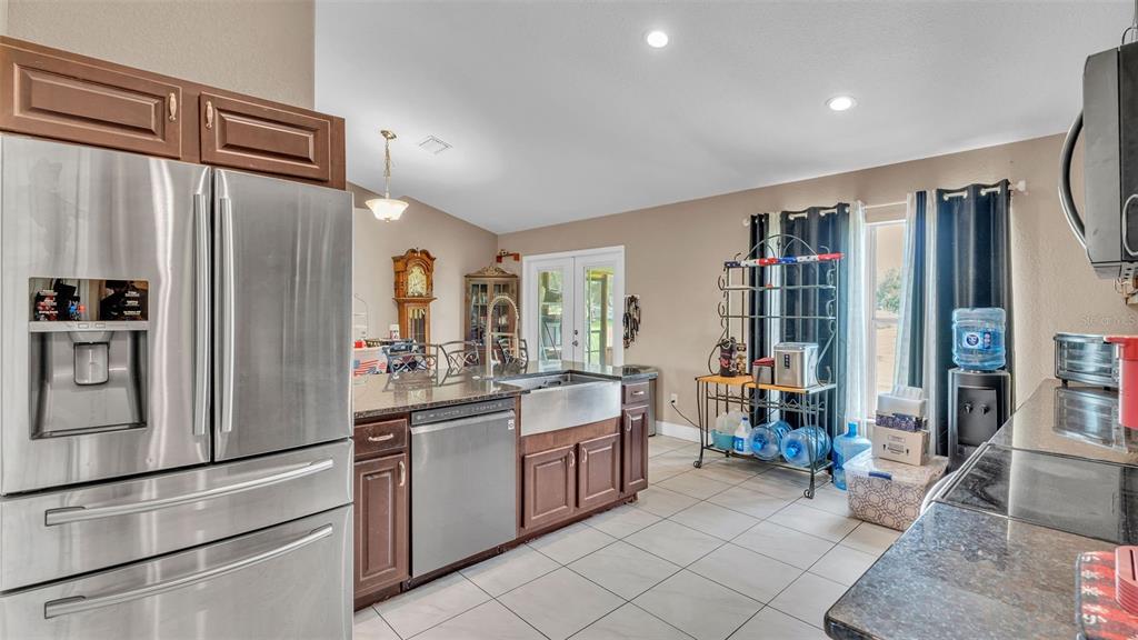 39360 Sparkman Road Dade City, FL 33525 - Photo 11 of 40 a kitchen with stainless steel appliances a refrigerator and a stove top oven