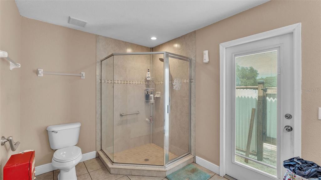 39360 Sparkman Road Dade City, FL 33525 - Photo 18 of 40 a bathroom with a glass shower door