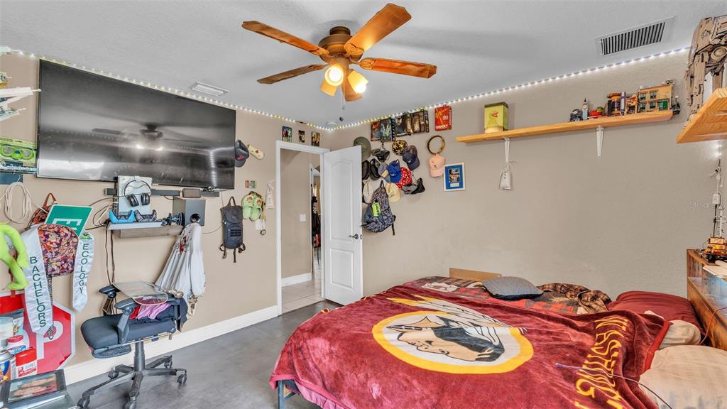 39360 Sparkman Road Dade City, FL 33525 - Photo 23 of 40 a bedroom with a bed and a chandelier