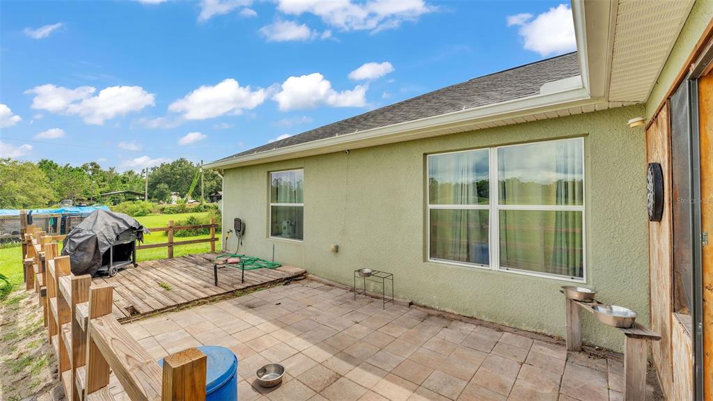 39360 Sparkman Road Dade City, FL 33525 - Photo 37 of 40 a view of a patio with table and chairs with wooden floor and fence