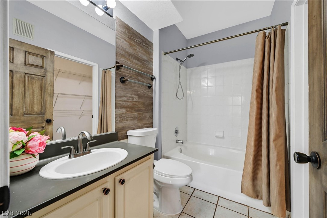8555 West Russell Road, Unit 2069 Las Vegas, NV 89113 - Photo 20 of 27 Functional bathroom featuring a shower-tub combo, vanity with ample storage, and warm wood accents.