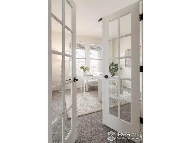 a kitchen with stainless steel appliances kitchen island granite countertop a refrigerator a stove a sink with island chairs and wooden floor