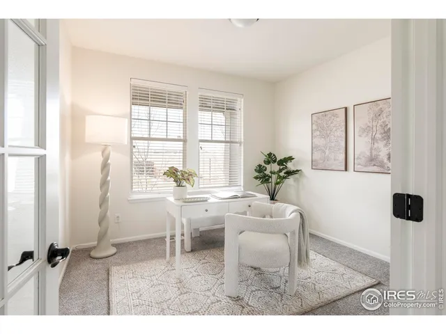 a living room with furniture a large window and dining table