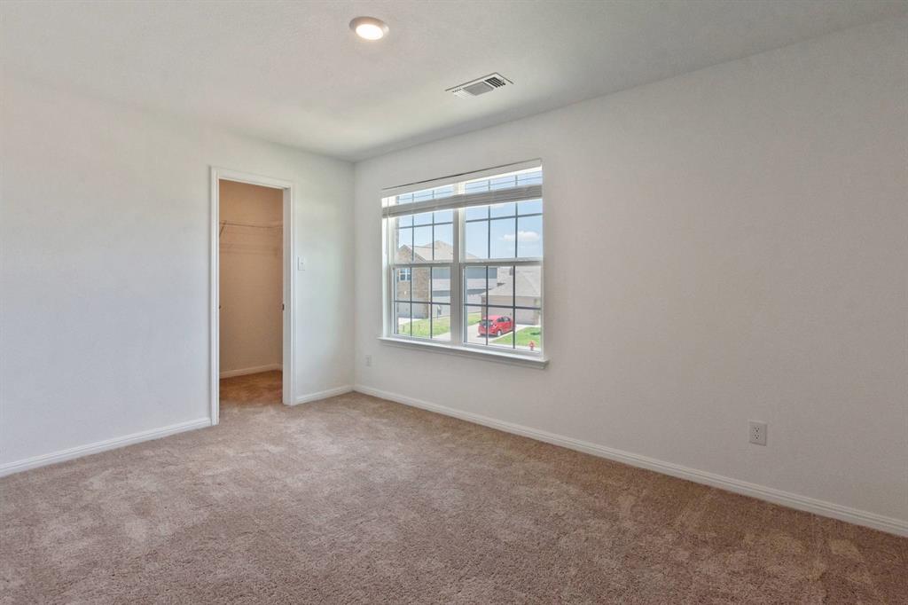 16429 Farmhouse Lane Elgin, TX 78621 - Photo 9 of 22 Carpeted room featuring a window with grid patterns, a recessed ceiling light, and an open closet