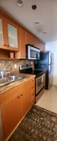 a kitchen with stainless steel appliances granite countertop a stove a sink and a microwave