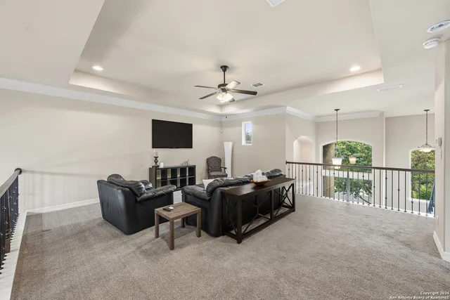 a view of a white house with a large tree and plants