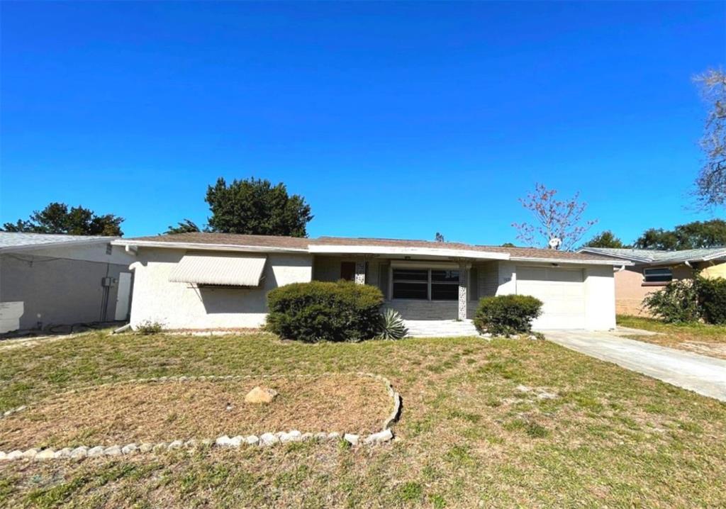 7335 Ashwood Drive Port Richey, FL 34668 - Photo 1 of 12 a view of a house with a yard