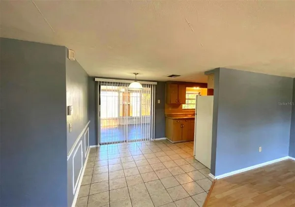 a view of a kitchen with a sink and an empty room