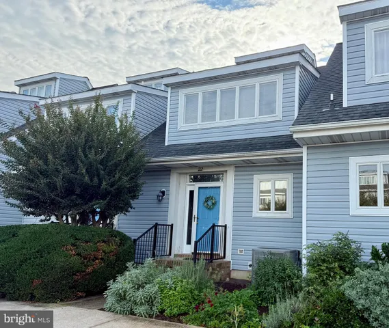 a view of a brick house with a yard and plants