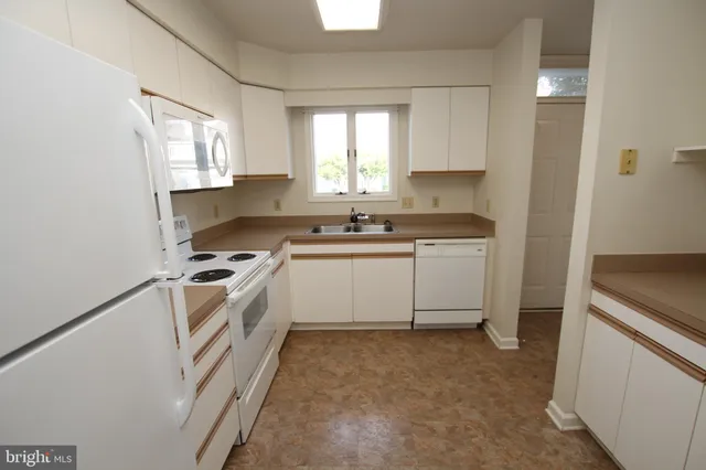 a kitchen with a stove sink and cabinets