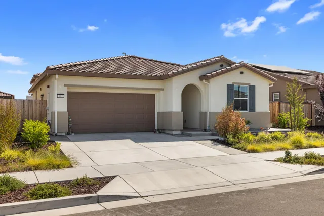 a front view of a house with a yard and garage