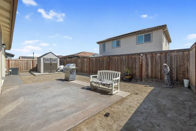 a view of a house with backyard and wooden fence