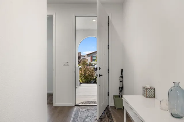a large white kitchen with lots of counter space a sink dishwasher and a stove with wooden floor