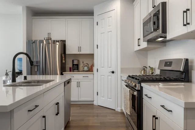 a kitchen with stainless steel appliances granite countertop a refrigerator sink and cabinets