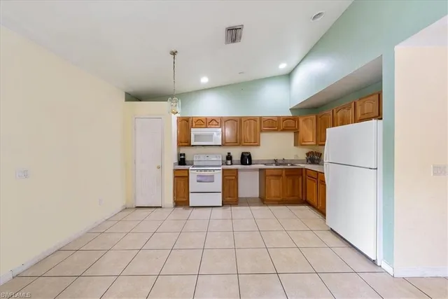 a kitchen with stainless steel appliances granite countertop a refrigerator and a stove top oven