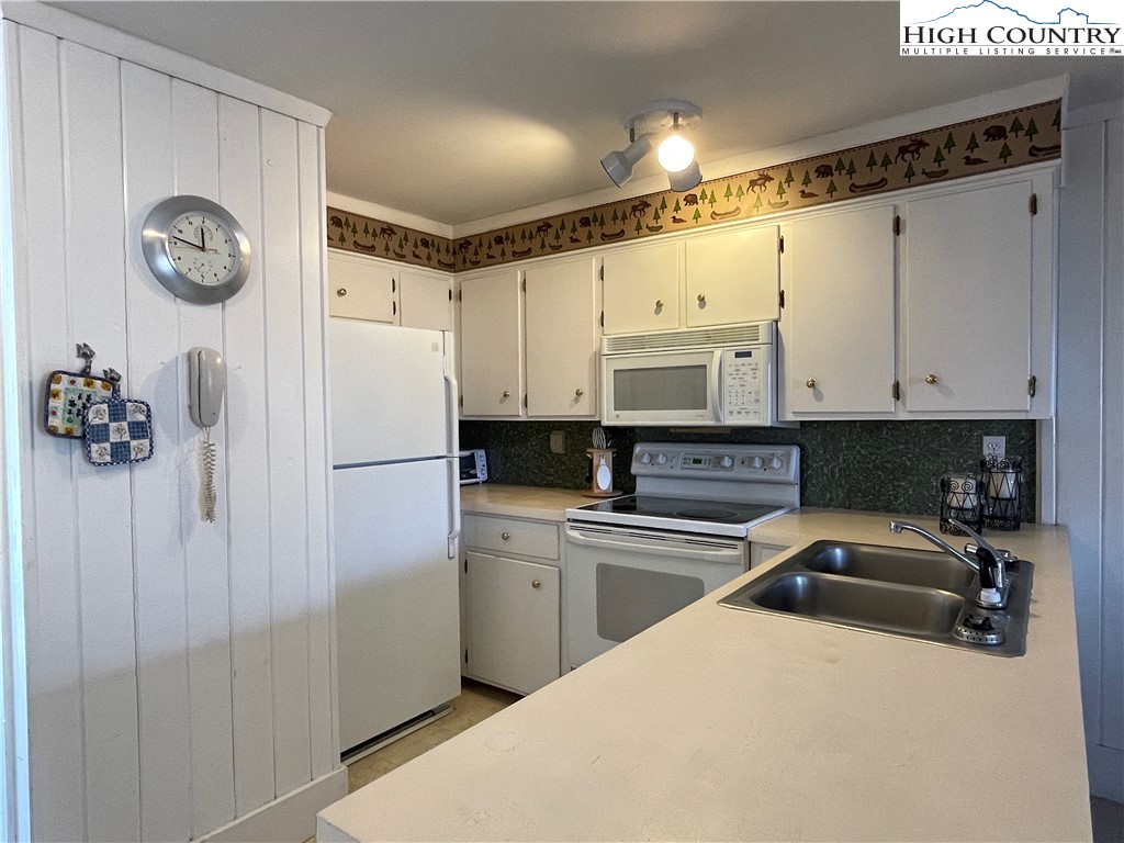 102 Skiview Lane, Unit A3 Beech Mountain, NC 28604 - Photo 2 of 20 a kitchen with a refrigerator a sink and cabinets