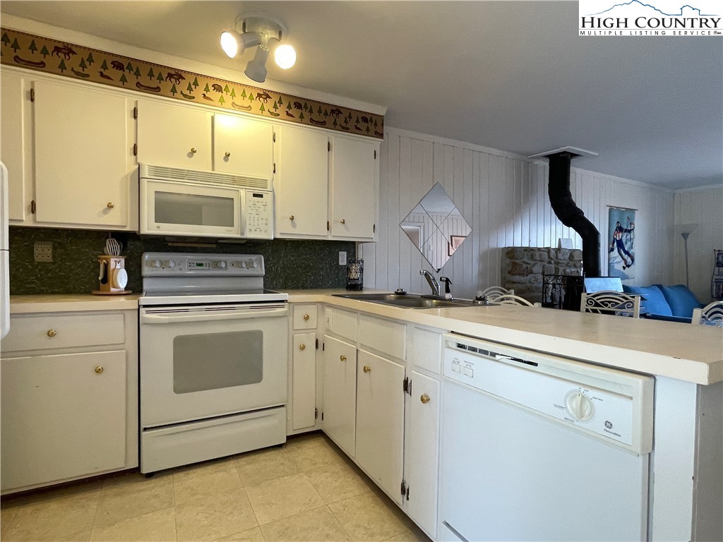 102 Skiview Lane, Unit A3 Beech Mountain, NC 28604 - Photo 3 of 20 a kitchen with stainless steel appliances granite countertop a sink a stove and a refrigerator