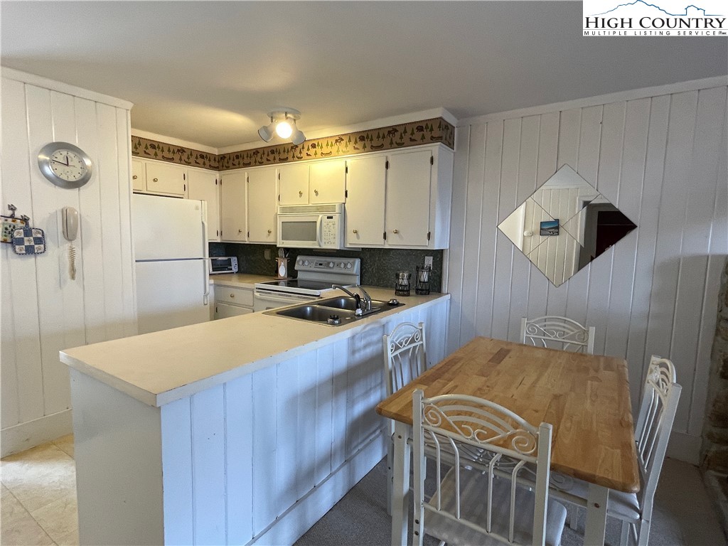 102 Skiview Lane, Unit A3 Beech Mountain, NC 28604 - Photo 4 of 20 a kitchen with stainless steel appliances granite countertop a sink stove and refrigerator