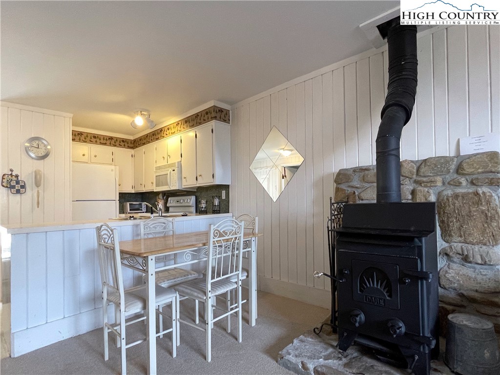 102 Skiview Lane, Unit A3 Beech Mountain, NC 28604 - Photo 9 of 20 a kitchen with a table chairs and a refrigerator