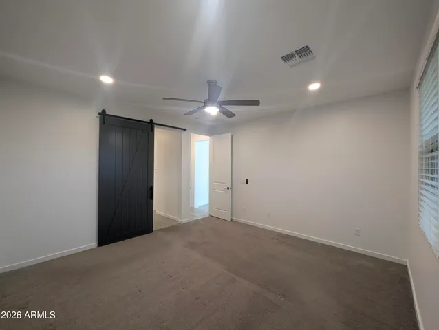 a walk in closet with white cabinets