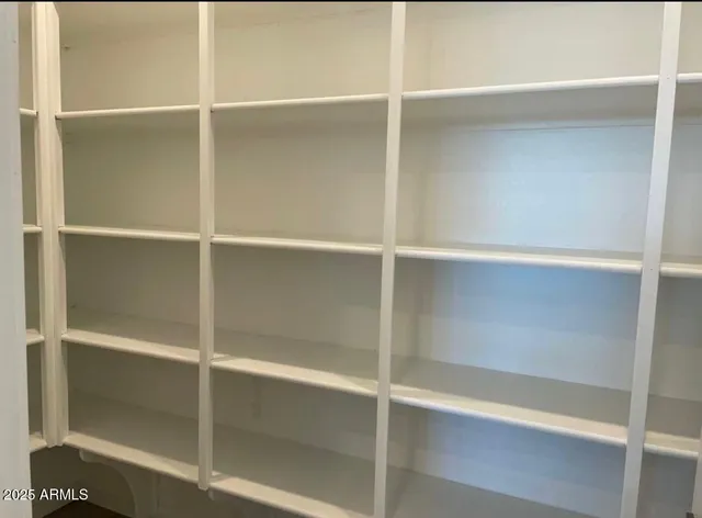 a view of a hallway to room with wooden floor