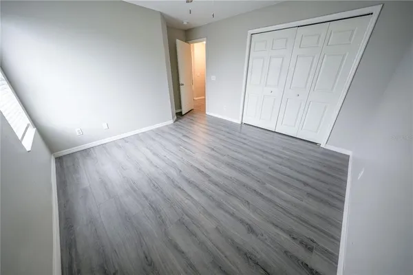 a view of an empty room with wooden floor