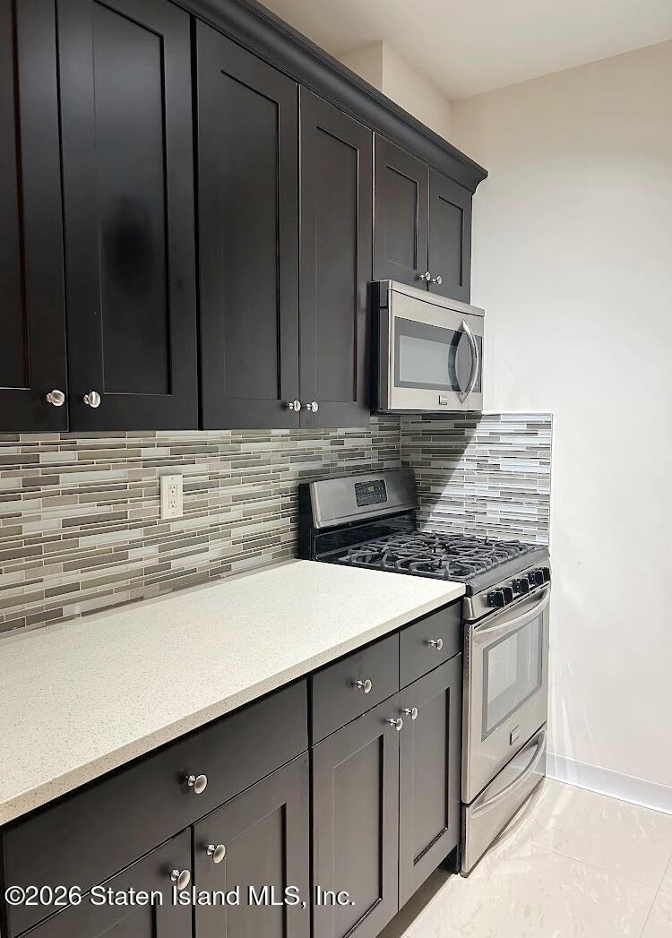 1235 Forest Hill Road, Unit 1G Staten Island, NY 10314 - Photo 5 of 11 a kitchen with stainless steel appliances granite countertop a stove and a microwave oven