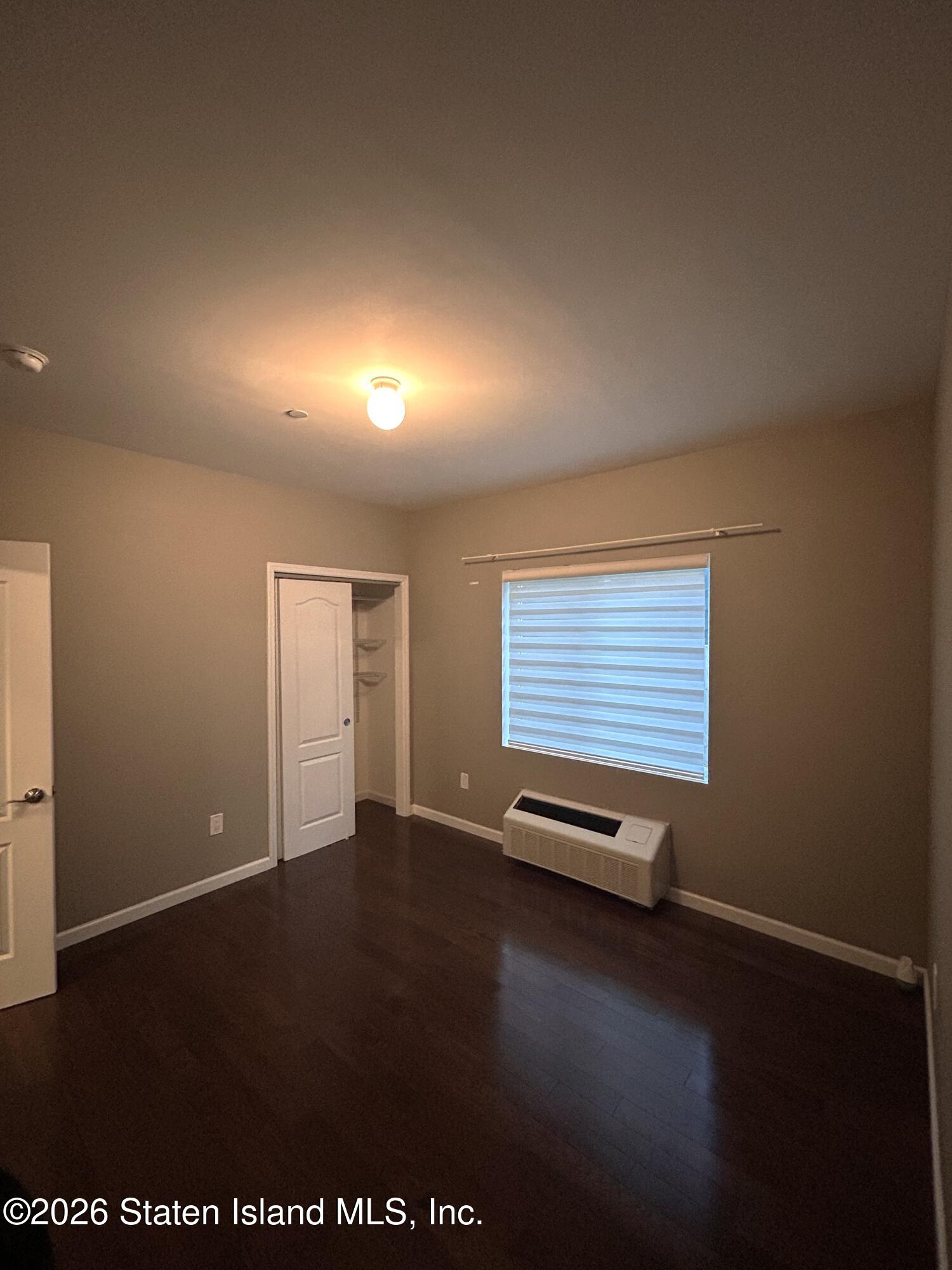 1235 Forest Hill Road, Unit 1G Staten Island, NY 10314 - Photo 9 of 11 an empty room with windows