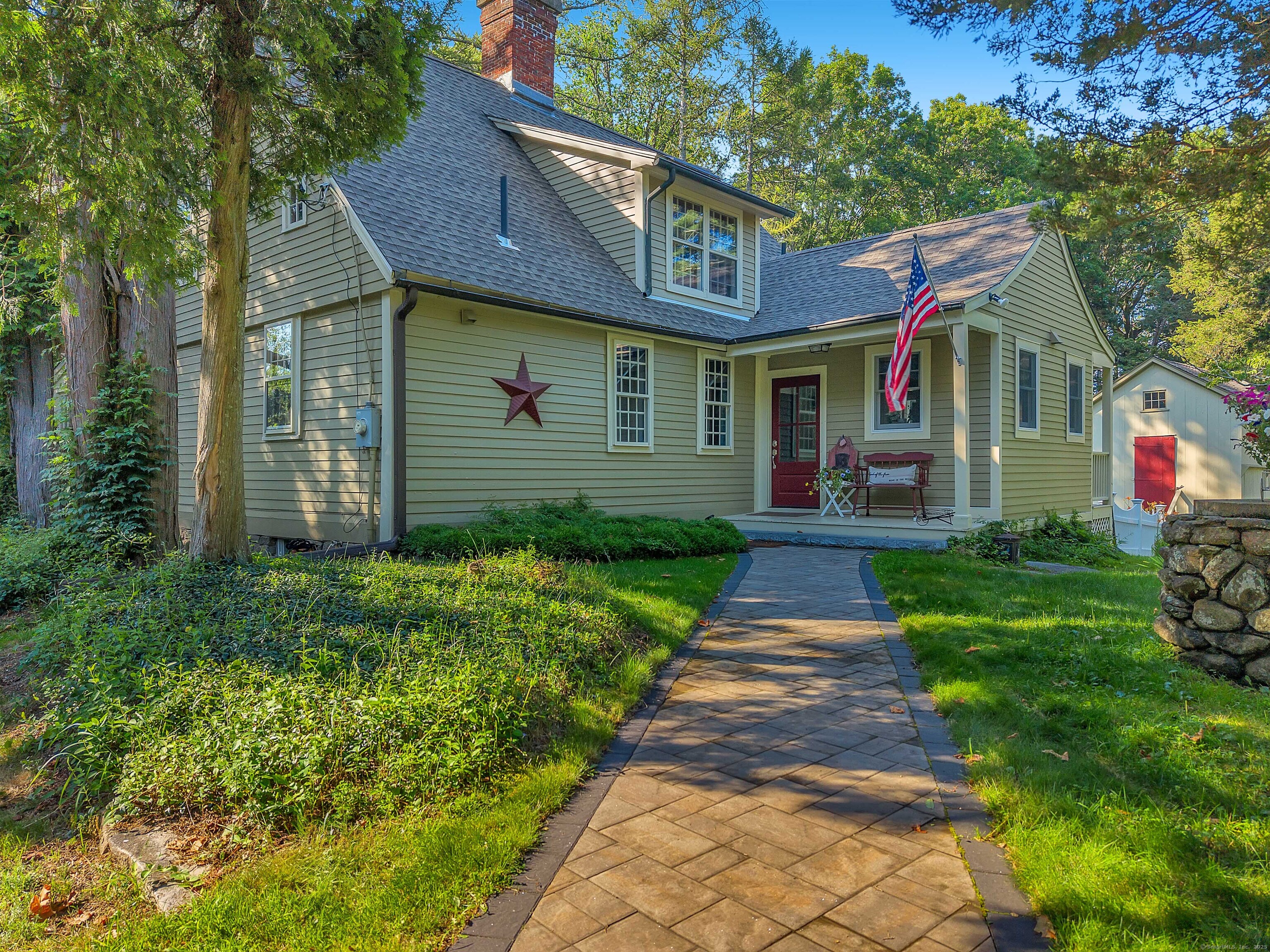 a front view of a house with a yard and potted plants