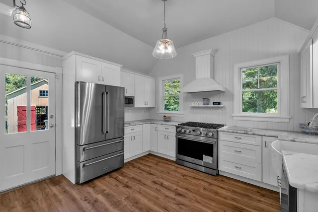 a kitchen with a sink cabinets stainless steel appliances and windows