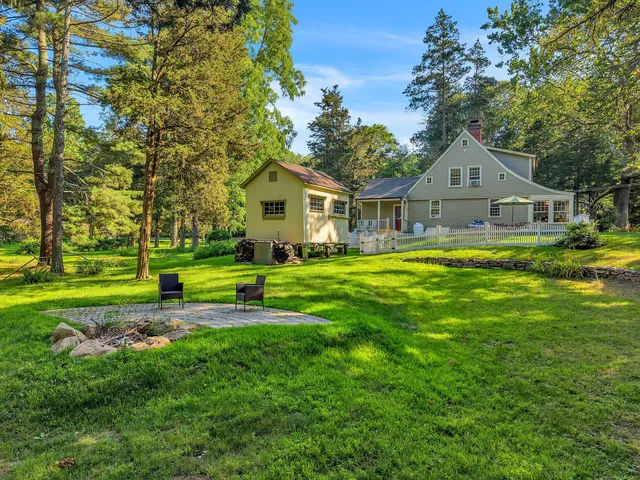 a view of a house with a big yard and large trees