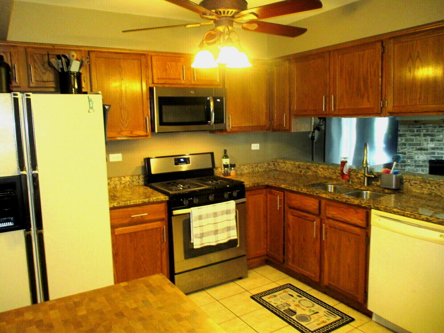 865 Tamarac Boulevard Addison, IL 60101 - Photo 9 of 21 a kitchen with stainless steel appliances granite countertop a sink a stove and a refrigerator