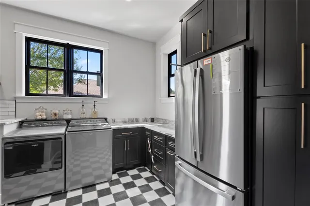 a kitchen with stainless steel appliances granite countertop a refrigerator a sink a stove and island