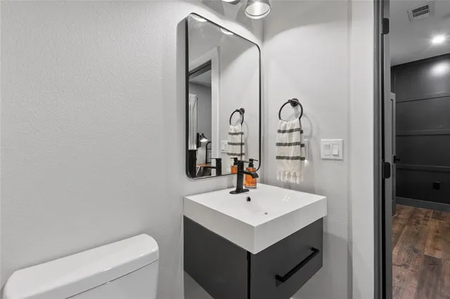 a bathroom with a sink a toilet and a mirror