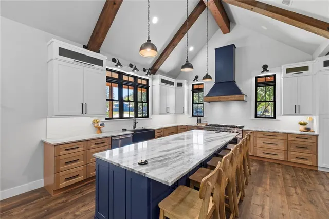 a kitchen with granite countertop a stove a sink and a refrigerator