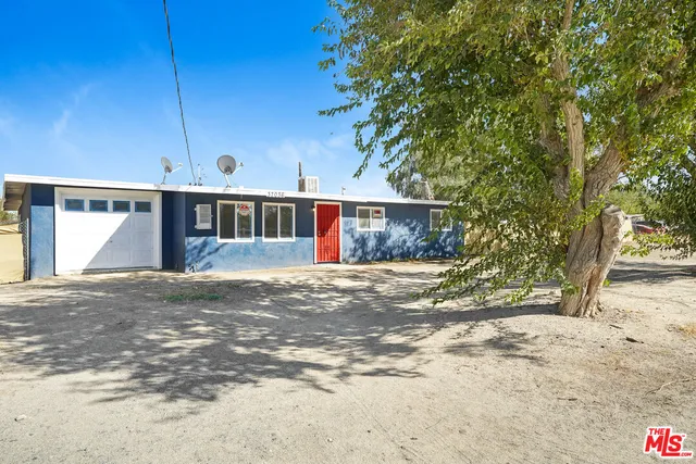 a view of a house with a yard and tree