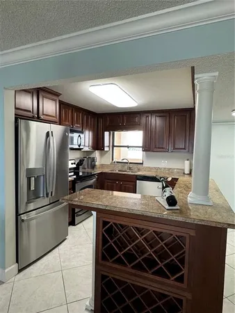 a kitchen with a sink a refrigerator and cabinets